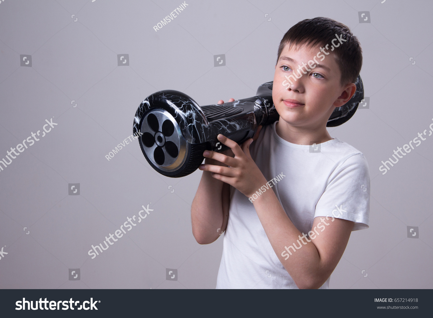 stock-photo-a-teenager-in-a-white-t-shirt-holds-a-black-hoverboard-or-gyro-footer-on-his-shoulder-657214918.jpg